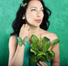 a woman in a bikini holding a plant 